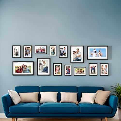 Set of 14 black photo frames displayed on a wall above a blue sofa, creating a cohesive gallery.