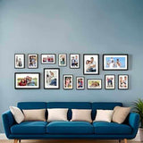 Set of 14 black photo frames displayed on a wall above a blue sofa, creating a cohesive gallery.