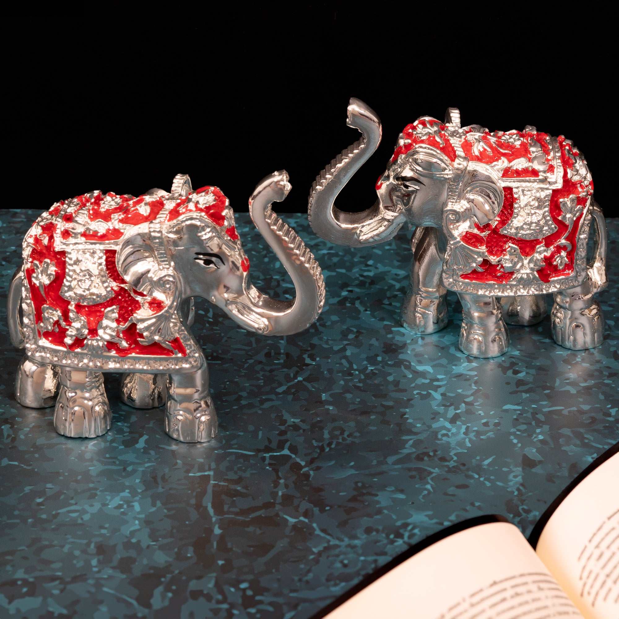 Pair of handcrafted silver-finish elephant idols with intricate detailing, ideal for spiritual ambiance and blessings.